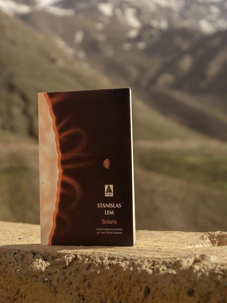 Solaris de Stanisław Lem, posé sur un muret, montagnes enneigées au loin